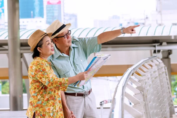 Casal Viajantes Idosos Usam Chapéu Com Bagagem Segurando Mapa Papel — Fotografia de Stock