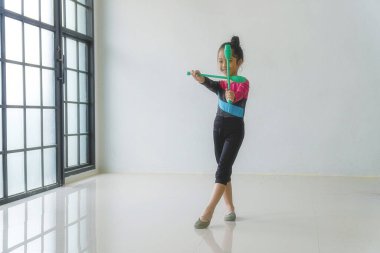 Çekici küçük kız evde neşe içinde jimnastik yapıyor. Jimnastikçi çocuklar stüdyoda vücut çalışmalarını esnetiyorlar. Çocuk konsepti için yaşam tarzı hobisi.