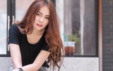 Fotokopi alanı olan bir bardak köpüklü buzla neşeli genç bir kadın. Kahverengi uzun saçlı mutlu kız. Soğuk kola buzlu. Kameraya bakıyor..