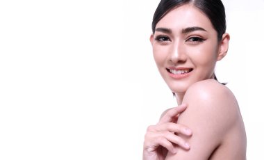 Beyaz arka planda izole edilmiş gülümseyen genç bir kadın. Asyalı mutlu kız kameraya bakıyor. Cilt bakımı stüdyo beyazında sağlıklı genç kadınlarla karşılaşıyor.