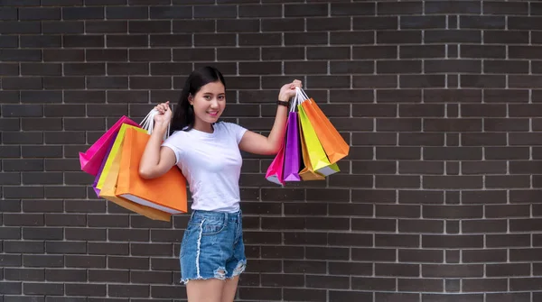 Jovem Alegre Atraente Animado Segurando Sacos Compras Coloridos Paredes Concreto — Fotografia de Stock