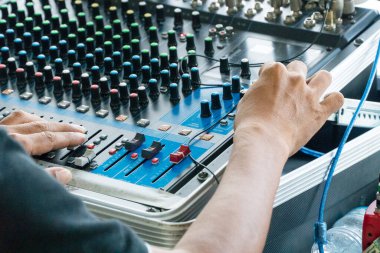 Büyük bir yüksek kurgu sisteminin konsolunu kontrol eden adamın elleri. Açık havada ses ekipmanı.