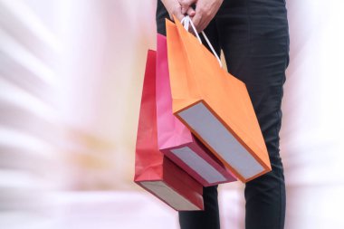 Yakınlaştırma efektli alışveriş torbaları taşıyan bir kadın eli. mutluluk, tüketim, satış ve insanlar konsepti.
