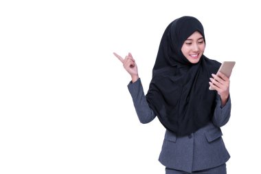 Beyaz arka planda izole edilmiş akıllı telefonuna bakan tesettürlü Müslüman bir iş kadını. Gülümseyen genç Arap kadınları cep telefonlarını kopyalama alanı ile tutuyorlar.
