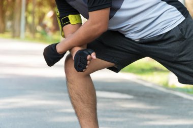 Adam parkta koşmadan önce ısınıyor ve vücudunu esnetiyor. Spor ve sağlık konsepti .