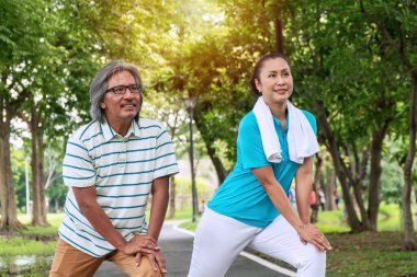 Yaşlı çift egzersiz konsepti. Yaşlı adam ve kadın halka açık parkta birlikte egzersiz yapmadan önce geriniyorlar.. 