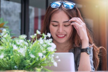 Başarılı bir iş hedefi kavramı. Kahve dükkanında bilgisayarla çalışan gülümseyen iş kadını..