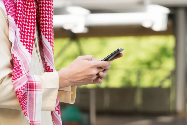 Orta Doğulu genç bir iş adamının eli akıllı telefon kullanıyor. Teknoloji konsepti.