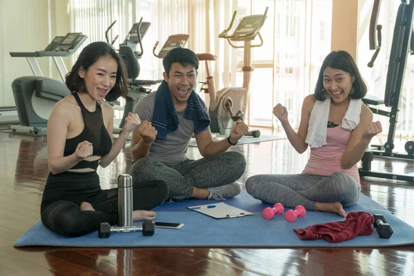 Grupo Jóvenes Deportistas Sentados Esterilla Yoga Juntos Levantan Las Manos —  Fotos de Stock