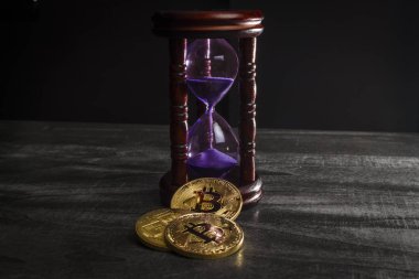Kum saatinin yanında bitcoin şeklinde paralar.