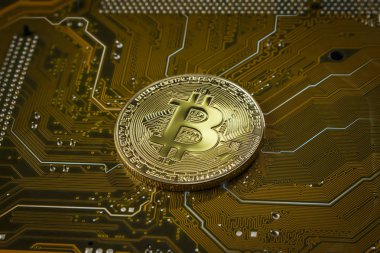 Sarı bir anakart üzerinde bitcoin şeklinde sikke