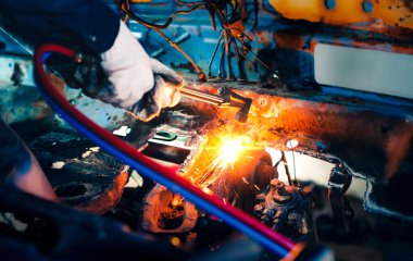 Kapalı el yapımı ağır sanayi işçisi, metal fabrikası işlemleri üzerinde çalışıyor. Gaz kesme makinesiyle çeliği keserek kazan fabrikasında kalın çeliği kesiyor..