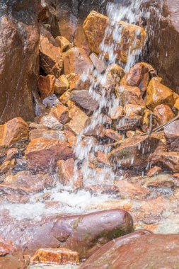 Kayalar ve taşlar moss plajda arasında küçük şelale