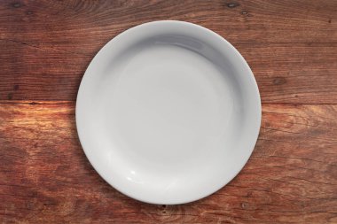 Ahşap bir masa üzerinde boş seramik yuvarlak plaka