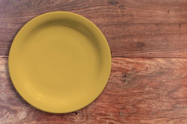 Ahşap arka plan üzerine boş seramik yuvarlak plaka