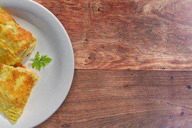 Omlet masanın üzerine eritilmiş peynir ile doldurulmuş