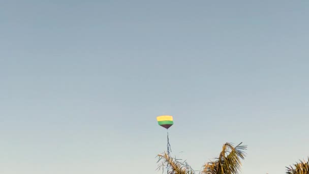 青い空の下での背景としての欠如のためにも 通常の風に乗って飛ぶ凧 — ストック動画
