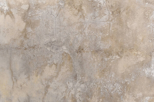 Трещины и пятна на поверхности полированной бетонной стены
