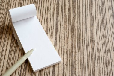 Yazı defteri ve kalem ahşap arka plan üzerinde boş beyaz kağıt sayfa