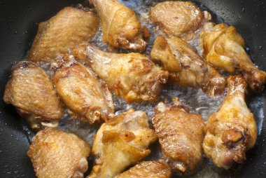 Bir tavada kızarmış tavuk yemek kanatlar
