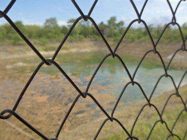 Su birikintisi ızgara çelik çit arkasında