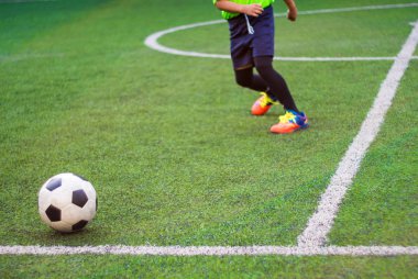 Futbolcular ilkokulda spor gününde yarışıyorlar.