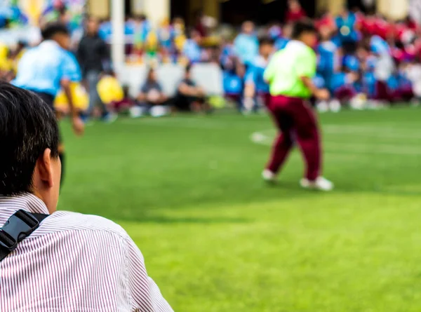 Man in work uniform Watch the football competitions beside footb — Stock Photo, Image