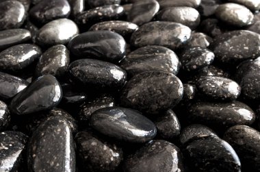 Yuvarlak kara taş şelale yanında zemin üzerine