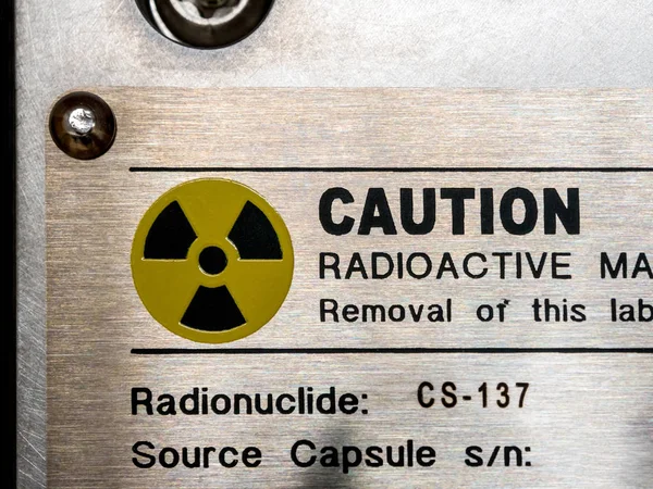 Señal de advertencia de radiación en la placa de identificación y el machanic contienen —  Fotos de Stock