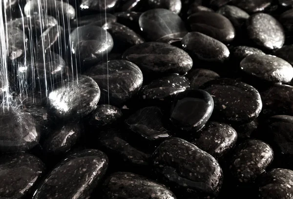 Pedra preta redonda no chão ao lado da cachoeira — Fotografia de Stock
