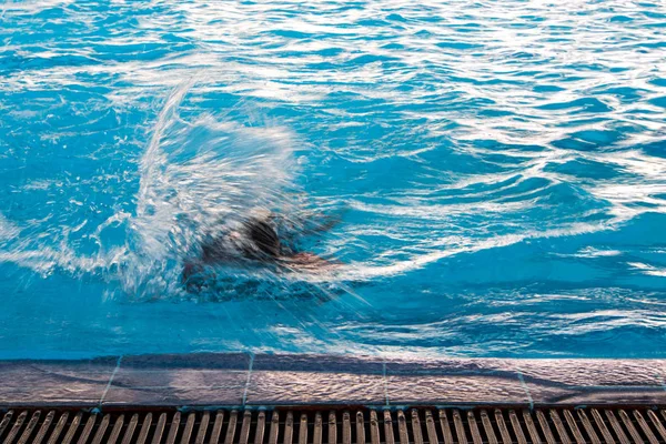 Nadador e ondulação na superfície da água na piscina — Fotografia de Stock