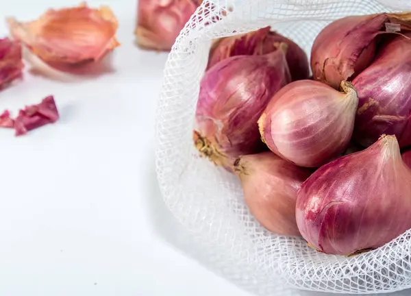 Cipolle rosse in sacchetto di maglia isolato su sfondo bianco — Foto Stock