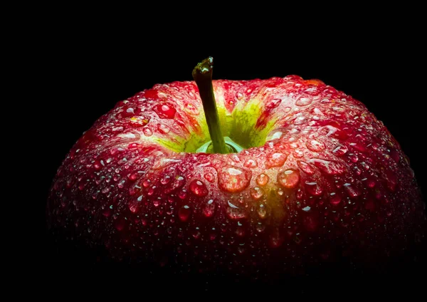 Gotas de água na superfície brilhante da maçã vermelha no fundo preto — Fotografia de Stock