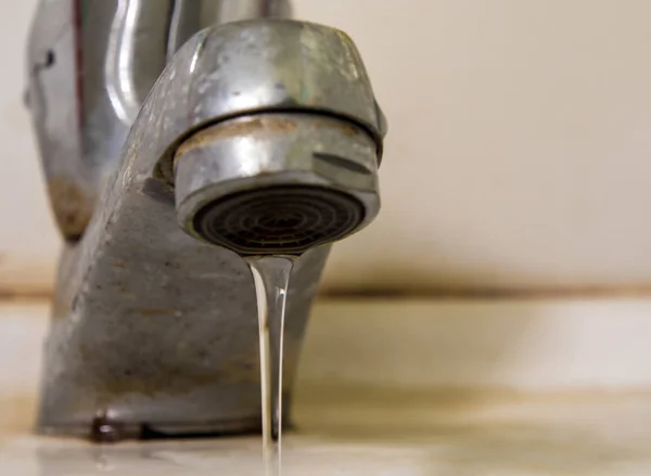 Des gouttes d'eau fuient de la vieille rouille et du robinet taché — Photo