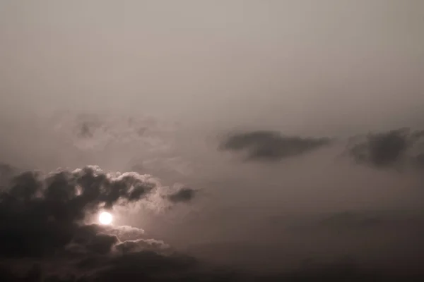 Graue, flauschige Wolken am Morgenhimmel mit Sonnenlicht — Stockfoto