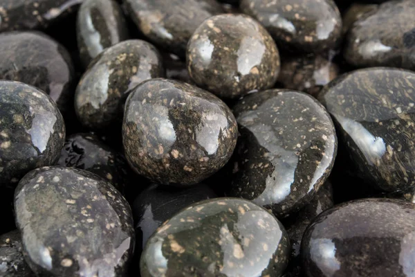 Runder schwarzer Stein auf dem Boden neben dem Wasserfall — Stockfoto