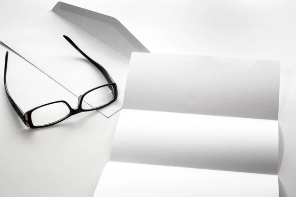 Blank of letter paper and envelope with eyeglasses — Stock Photo, Image