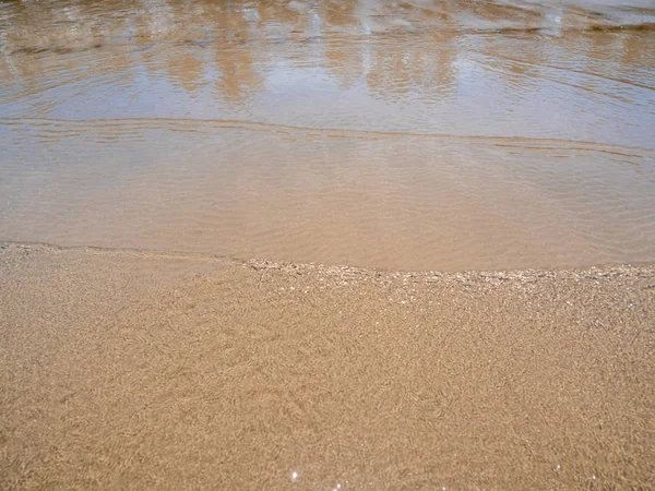 Light reflection on the surface of movement sea on sand beach — Stock Photo, Image