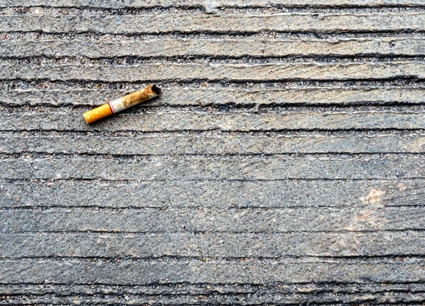 Der Zigarettenstummel auf dem Betonboden heruntergelassen — Stockfoto