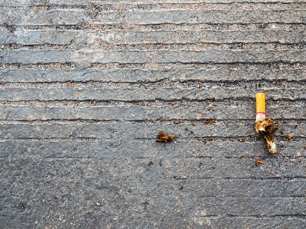 Le mégot de cigarette laissé tomber sur le sol en béton — Photo