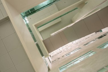 Koridordaki yüksek binadaki alçak görüş açısı binanın tepesindeki rahipten gelen gün ışığına bakıyor.