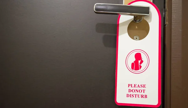 Do not disturb sign hanging on a door in a hotel