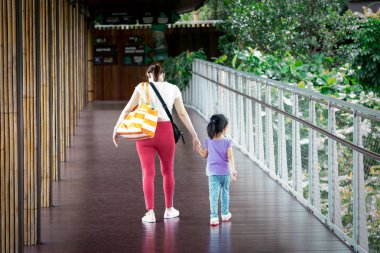 Anne ve kızı çocuk parkta yürürken