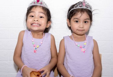 Beyaz backgro ile sandalye üzerinde oturan kadın Asya tek yumurta ikizi