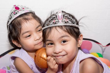 Beyaz backgro ile sandalye üzerinde oturan kadın Asya tek yumurta ikizi