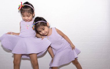 Beyaz backgro ile sandalye üzerinde oturan kadın Asya tek yumurta ikizi