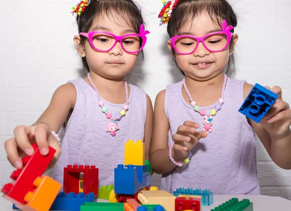 Feminino asiático gêmeos idênticos sentados na cadeira com branco backgro — Fotografia de Stock