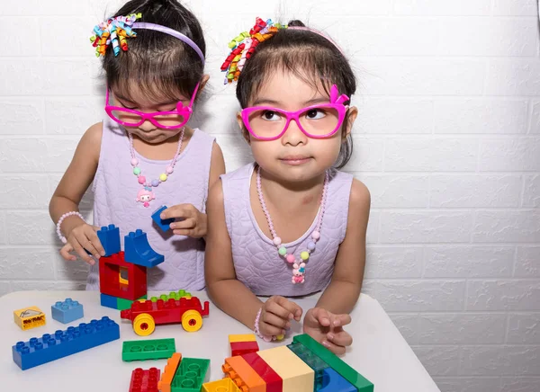 Feminino asiático gêmeos idênticos sentados na cadeira com branco backgro — Fotografia de Stock