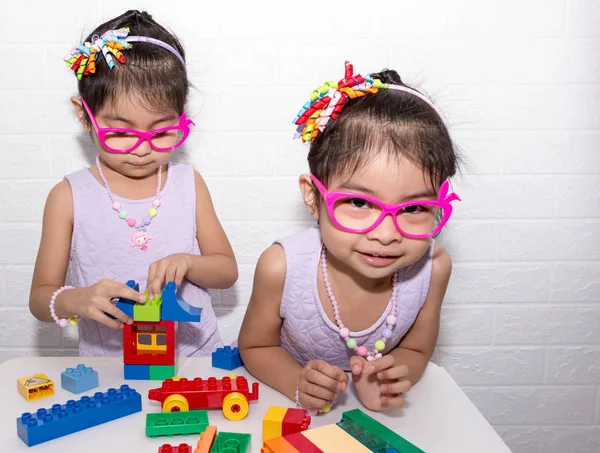 Weibliche asiatische eineiige Zwillinge sitzen auf Stuhl mit weißem Rücken — Stockfoto