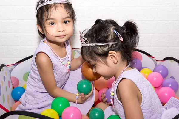 Beyaz backgro ile sandalye üzerinde oturan kadın Asya tek yumurta ikizi